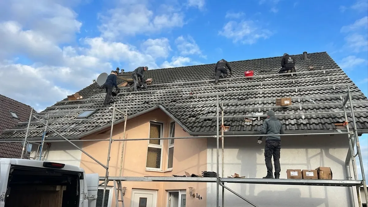 Solarmodule werden auf einem Satteldach montiert — fachgerechte Installation durch qualifizierte Partnerbetriebe