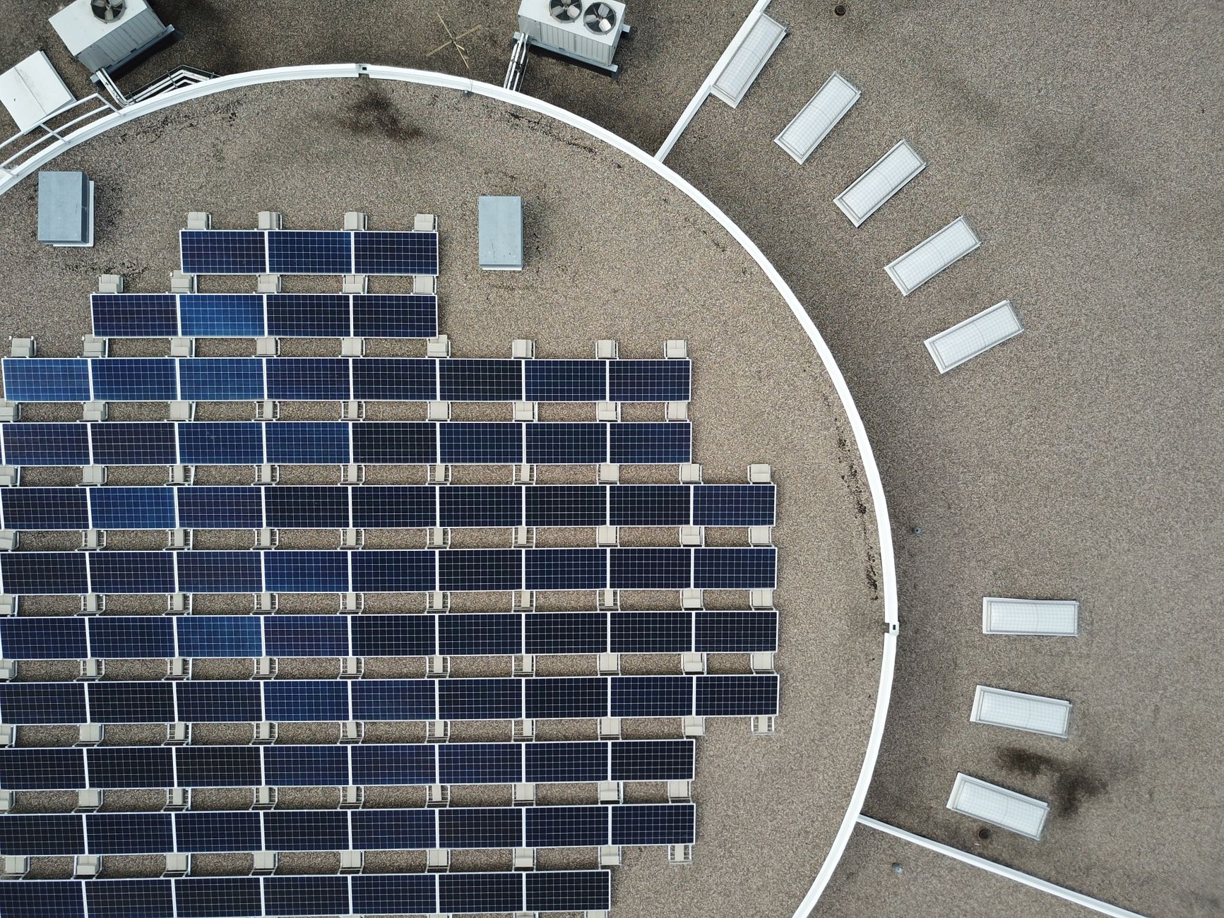 Luftaufnahme eines Flachdachs mit dicht gesetzten, aufgeständerten Solarmodulen