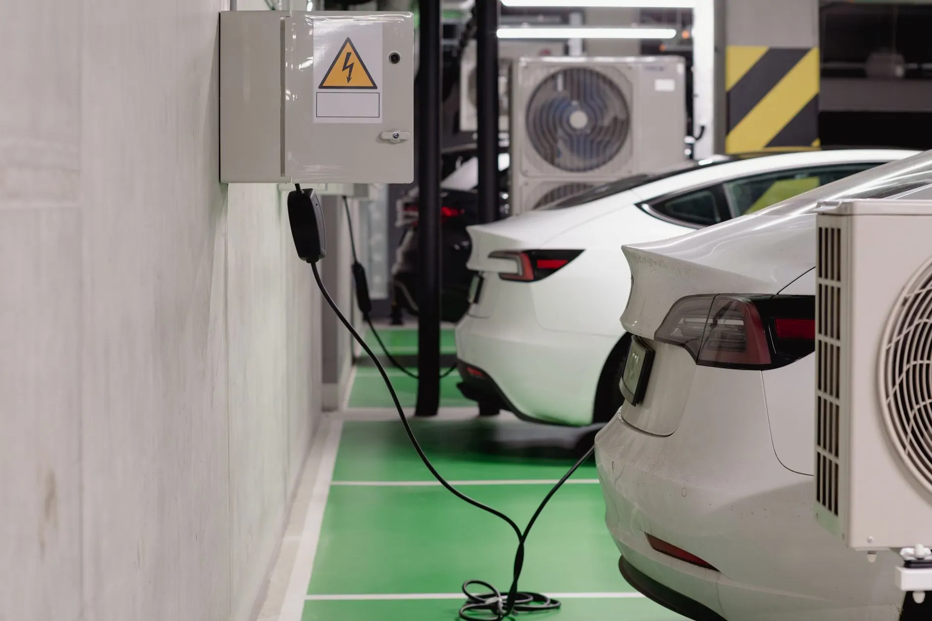 Mehrere Elektroautos laden gleichzeitig an Ladepunkten in einer modernen Tiefgarage