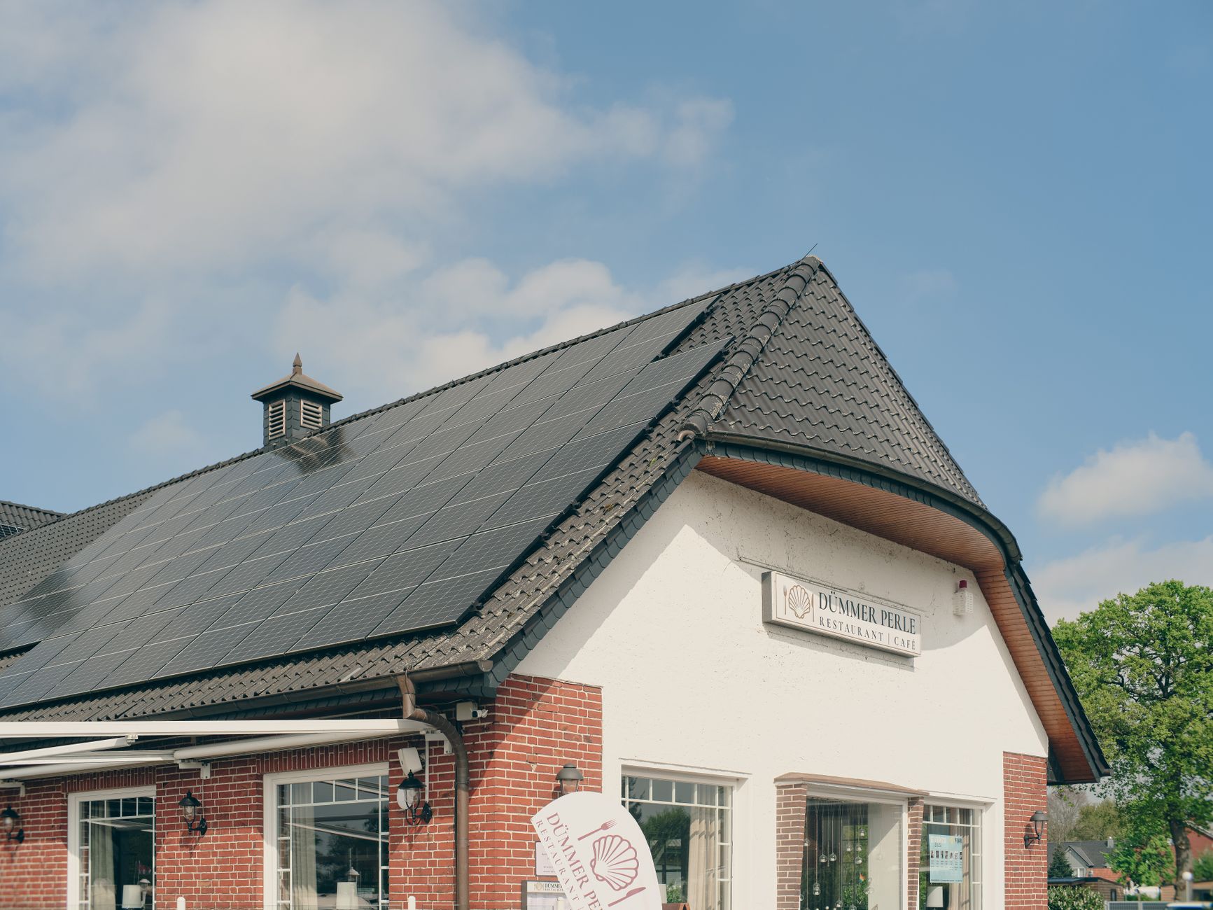Historisches Backsteingebäude mit Solarmodulen auf dem Dach — die Ausrichtung lässt sich nicht immer wählen, aber fast immer wirtschaftlich nutzen