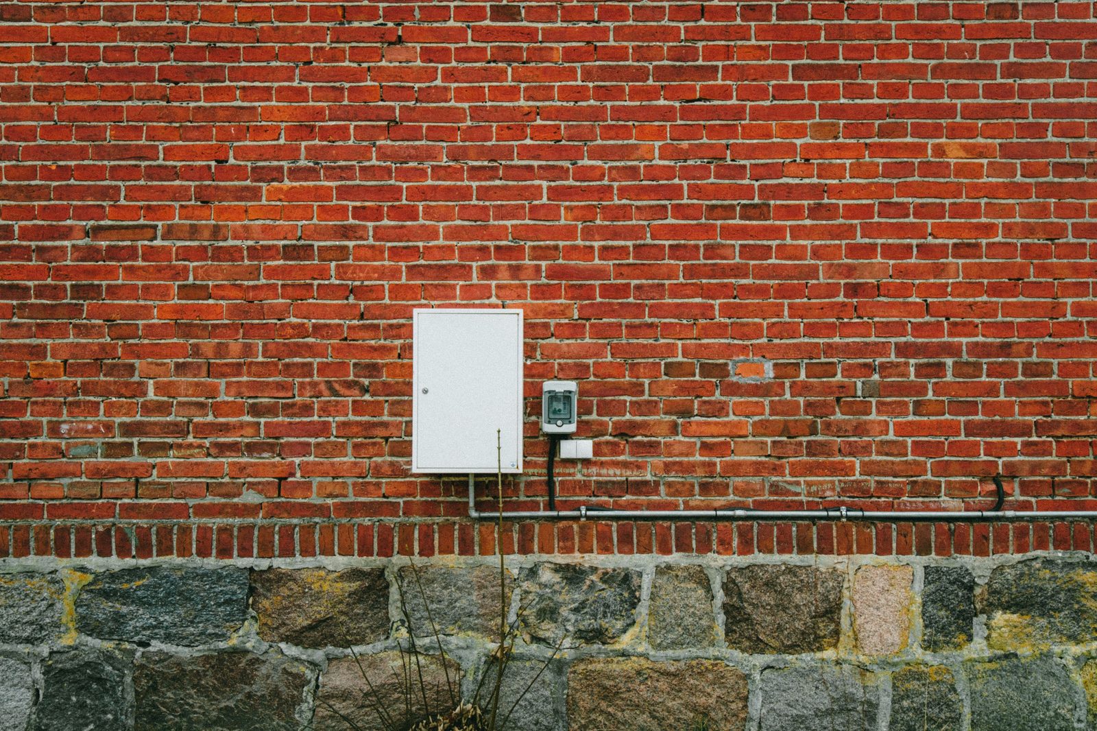 Stromzählerkasten an einer roten Backsteinmauer — steuerbare Verbrauchseinrichtungen wie Wallbox, Wärmepumpe und Speicher müssen seit 2024 beim Netzbetreiber angemeldet werden
