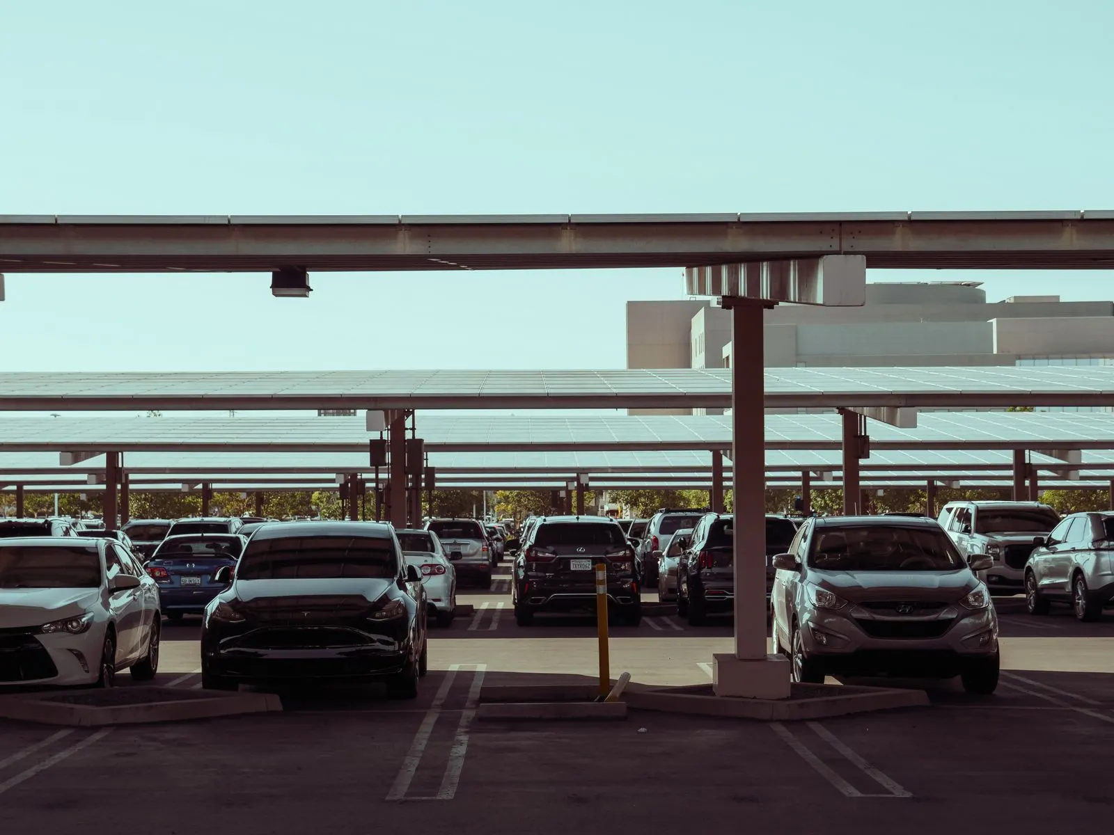 Autos unter einer Solar-Carport-Überdachung aus Photovoltaik-Modulen